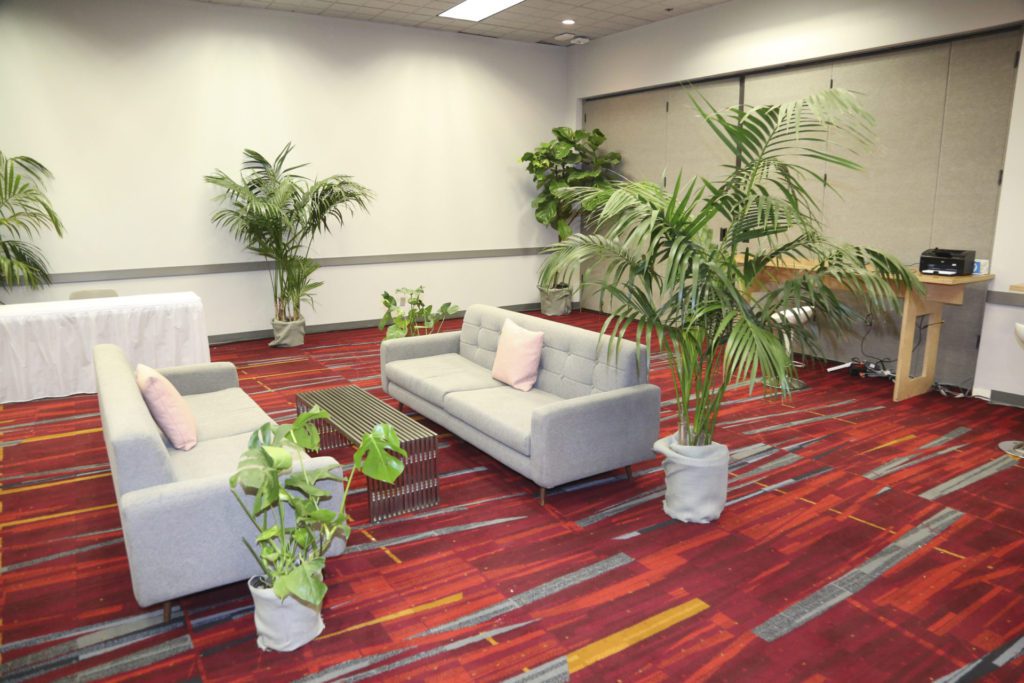 A trade show lounge with live plant rentals.