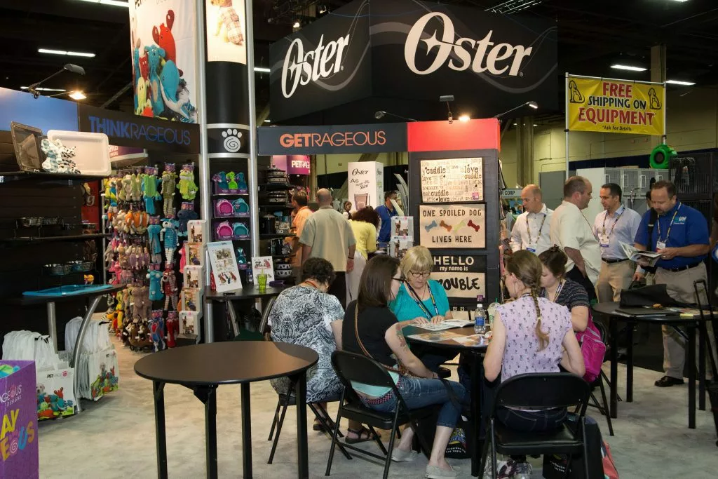 Group of people sitting together at a trade show booth.