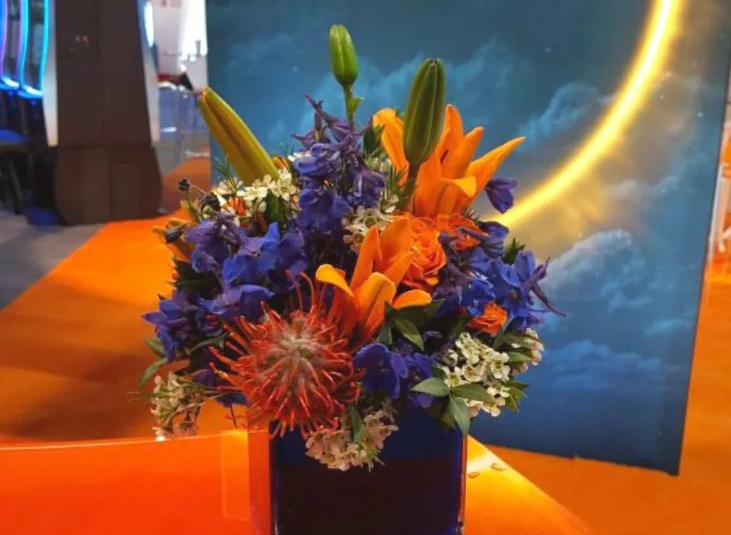 Bouquet of colorful purple and orange flowers in a purple vase.