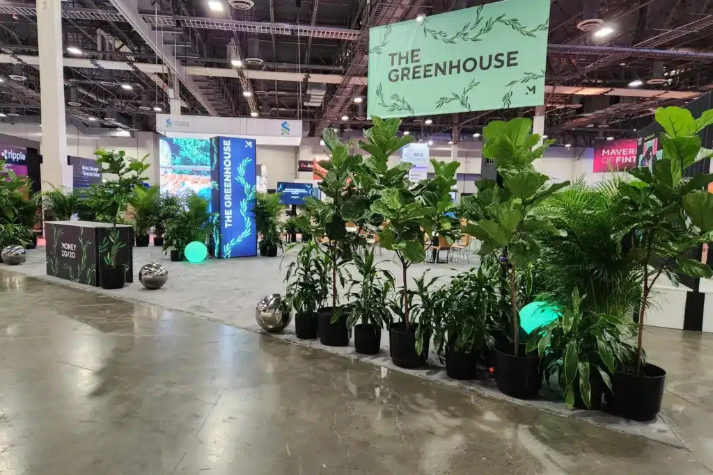 Row of tall plants at a trade show event.