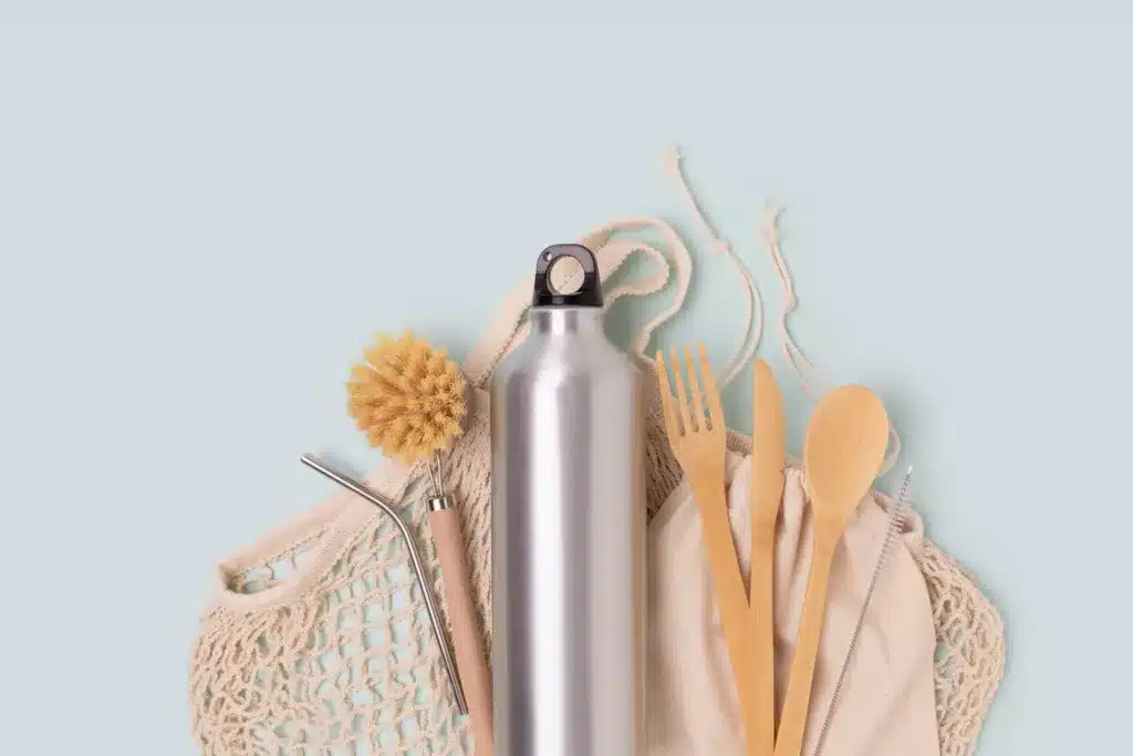 Reusable water bottle, metal straw, cloth reusable bag and bamboo utensils.