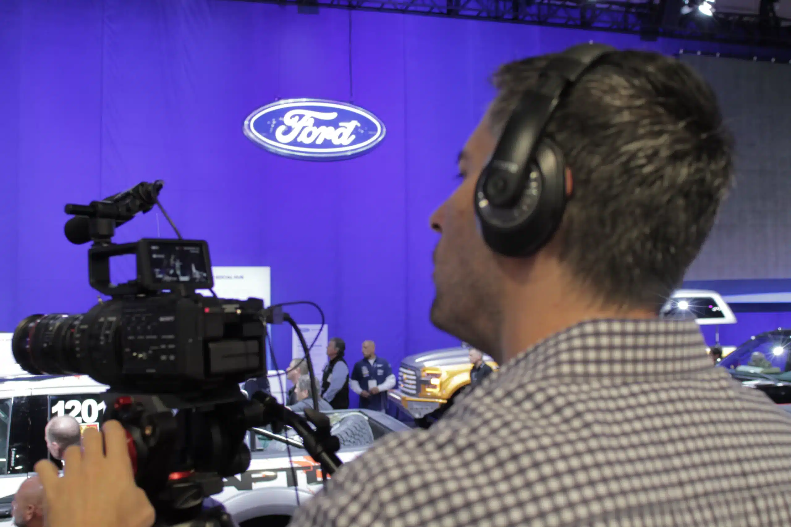 Man shooting videography at an automobile trade show in Las Vegas.