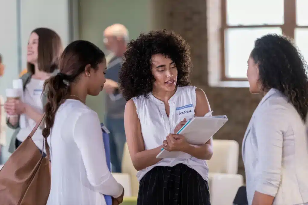 Woman greeting people attending a trade show conference.