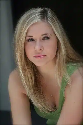 Woman with blond hair modeling a green tank top.