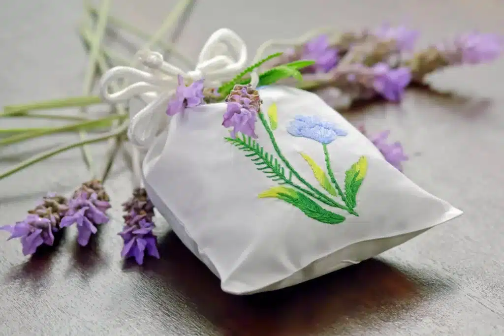 Small bag with embroidery of flowers with lavender in the background.