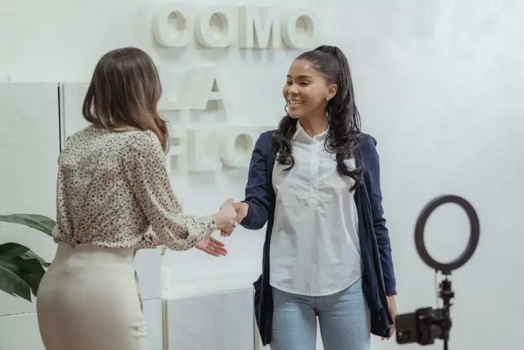 Two women shaking hands.