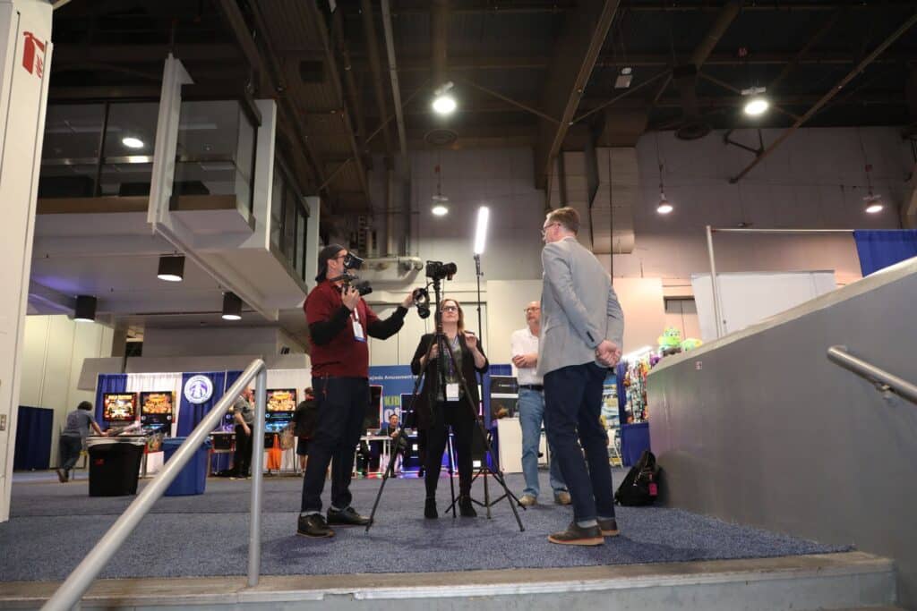 group of three people conducting a video shoot at a trade show